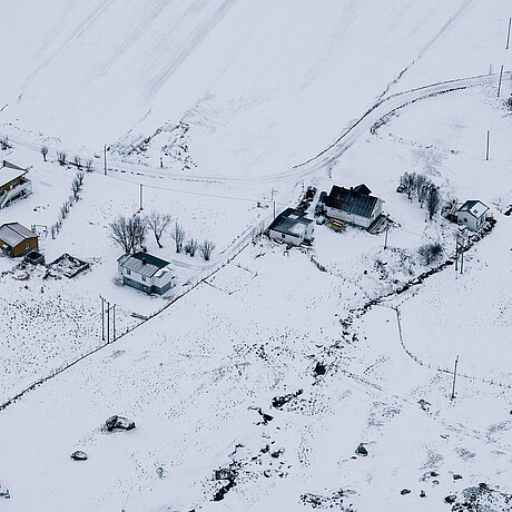 Snow-covered houses and fields.