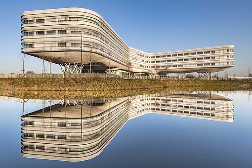 [Translate to Belgian Dutch:] Modern, langgerekt gebouw aan het water.
